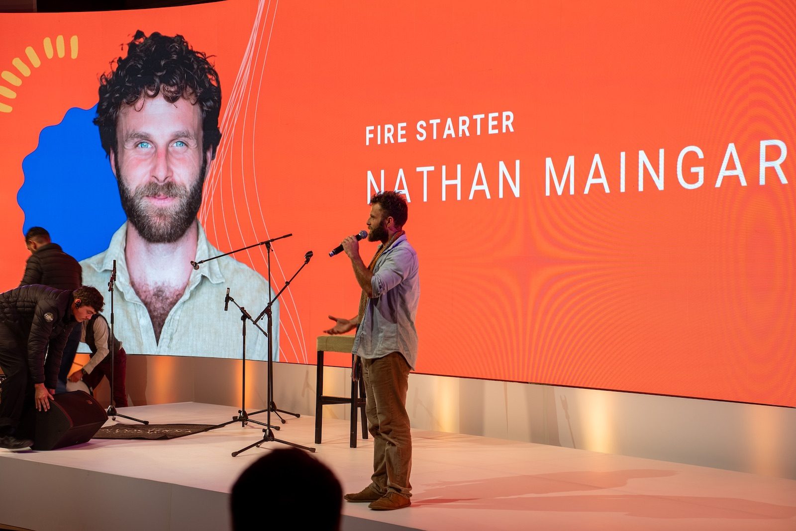Nathan Maingard on stage at EO Ignite, introduced on the big screen as a Fire Starter speaker